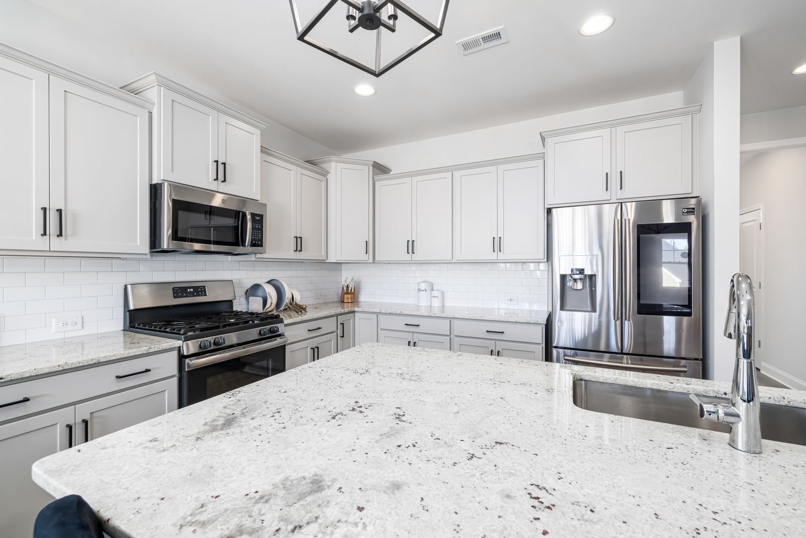 Modern kitchen with white cabinets and a granite countertop island